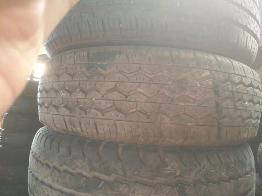 Os pneus usados secundam a mão montam pneus em segundo pneus de carro, em segundo pneu de automóvel de passageiros 185R14C